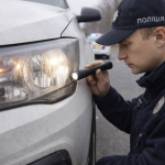 Поліцейський перевіряє несправну фару автомобіля під час дорожньої перевірки в Україні