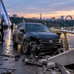 Пошкоджений Volkswagen на пішохідному мосту в Києві після ДТП, поруч патрульна поліція та уламки автомобіля. Ілюстративне зображення.
